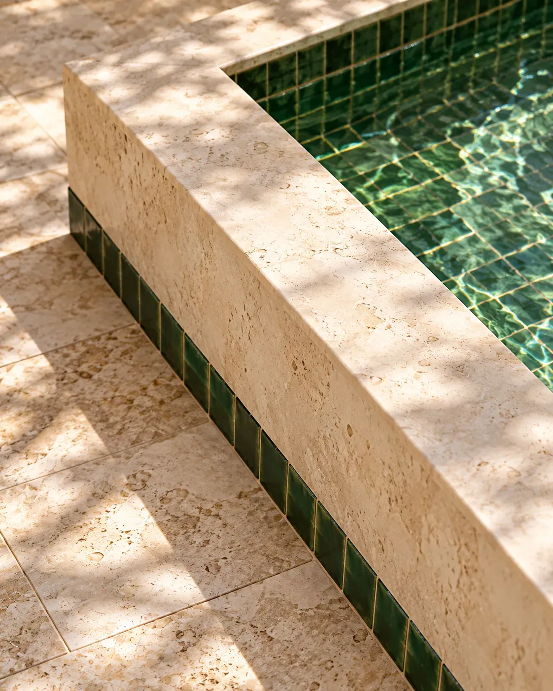 Green ceramic trim and pale stone at the fountain